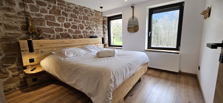 Chambre avec lit double et vue sur la nature.