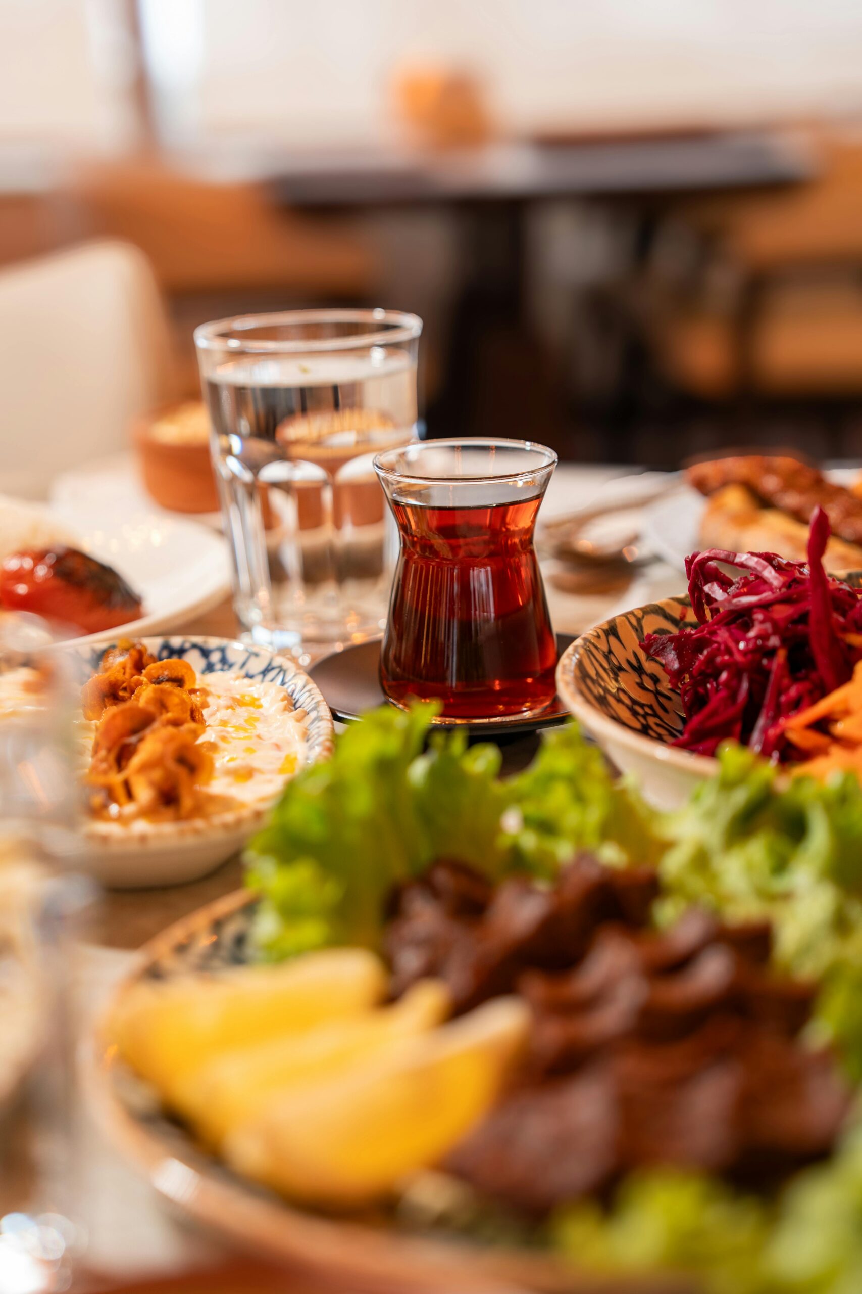 A vibrant display of Turkish tea and meze dishes with fresh greens, shot in a local Ünye eatery.